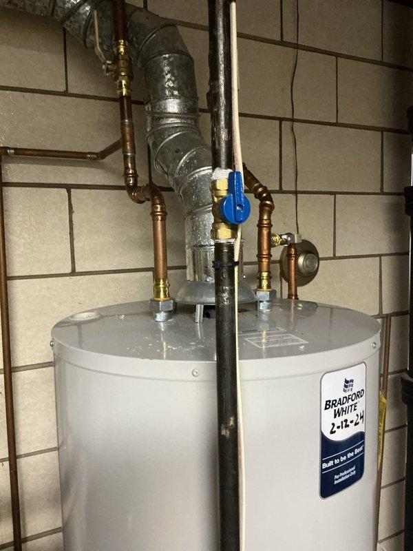 Responded to service call for water softener emitting foul odor. Upon arrival, inspected recently installed water softening system and associated plumbing connections. Evaluated Bradford White 50-gallon natural gas water heater and surrounding copper piping with brass fittings to determine source of odor complaint. Documented equipment specifications and installation configuration for diagnostic purposes.