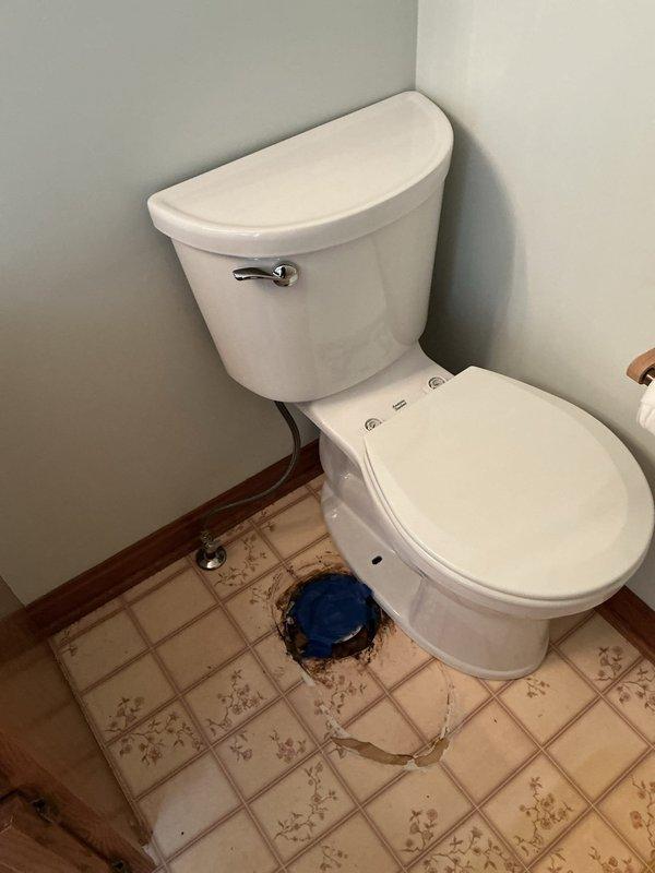 Responded to a service call for toilet issues with visible water damage and floor staining. Upon inspection, discovered significant leakage around the toilet base and floor drain area, evidenced by extensive brown discoloration and rust-colored staining on the ceramic tile flooring. Removed and reset the toilet to address the leak source, replacing the wax ring seal and toilet mounting bolts. Inspected the floor flange for damage and confirmed proper alignment and secure attachment to the subfloor. Reconnected the chrome water supply line with new compression fittings to ensure a watertight seal. Tested the toilet for proper operation, checking for leaks at the base and supply connection. Documented the existing floor damage and staining for customer records, noting that tile cleaning or replacement would be recommended to address cosmetic concerns from the previous water intrusion.