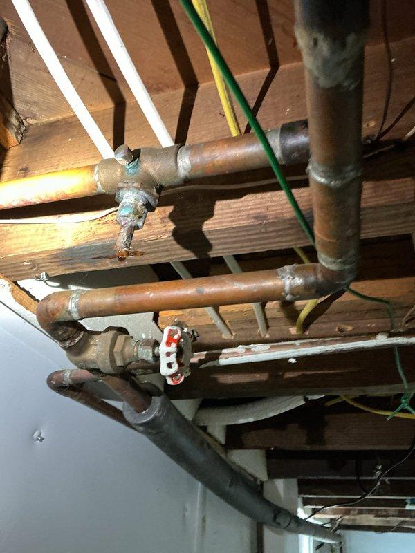 Replaced stuck return shut-off valve on third floor hydronic heating loop in basement. Installed additional air bleeder valves on the same heating loop to improve system performance and eliminate air pockets. Documented existing plumbing infrastructure including copper piping, connections, and baseboard heating unit components.