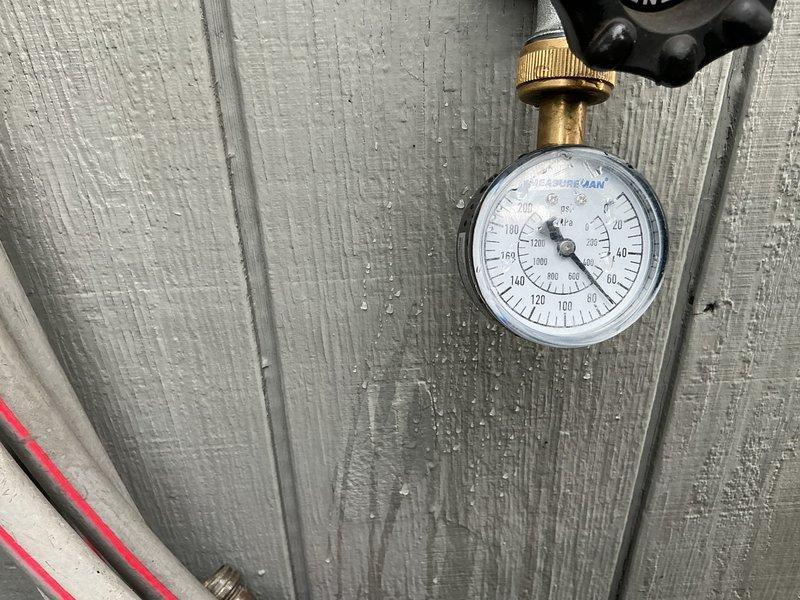 Replaced existing pressure reducing valve (PRV) and installed new 3/4"x3/4"x1/2" tank tee with tankless-style expansion tank to regulate water pressure and accommodate thermal expansion in the system. Work required careful handling due to existing polybutylene 3/4" supply line running to water manifold. Installation included brass fittings, pressure gauge, and black expansion tank mounted within wall cavity access panel, with all components tested and verified operational upon completion.