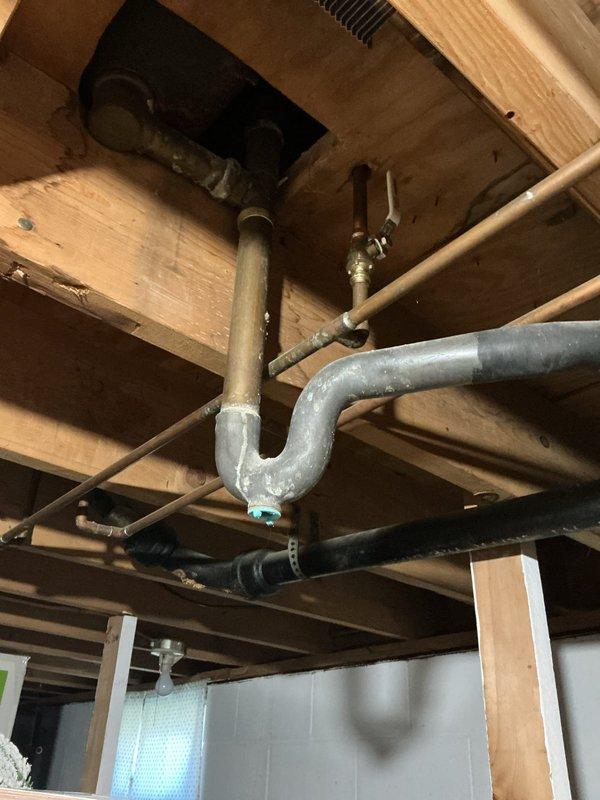 Responded to complaint of foul odor emanating from shower drain in 66-year-old residence with clay piping system. Accessed crawl space beneath bathroom to inspect drain assembly and trap configuration. Upon investigation, identified aging P-trap and drain connections showing signs of deterioration consistent with original clay pipe infrastructure. Documented existing plumbing conditions including galvanized and copper supply lines, drain trap assembly, and exposed joists for assessment. Photographed drainage system components to verify trap integrity and identify potential sources of sewer gas infiltration that could be causing the reported odor issue.