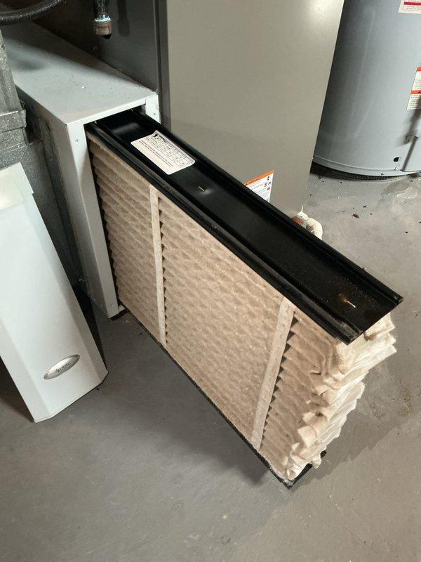 Completed routine MVP furnace maintenance visit including thorough inspection of heating system and air handler unit. Examined and documented condition of pleated air filter in black metal track assembly, inspected furnace cabinet and mechanical components in utility space, and verified proper installation of system brackets and hardware. All equipment found operating within normal parameters with no immediate service needs identified.