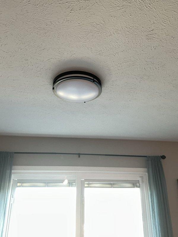 Completed installation of five new light fixtures throughout the residence, including a flush-mount ceiling fixture and a ceiling fan with integrated light kit. Additionally, relocated an existing ceiling fan to a new position, replaced the front porch light fixture, and installed a new light fixture in the utility room to improve illumination in the workspace.