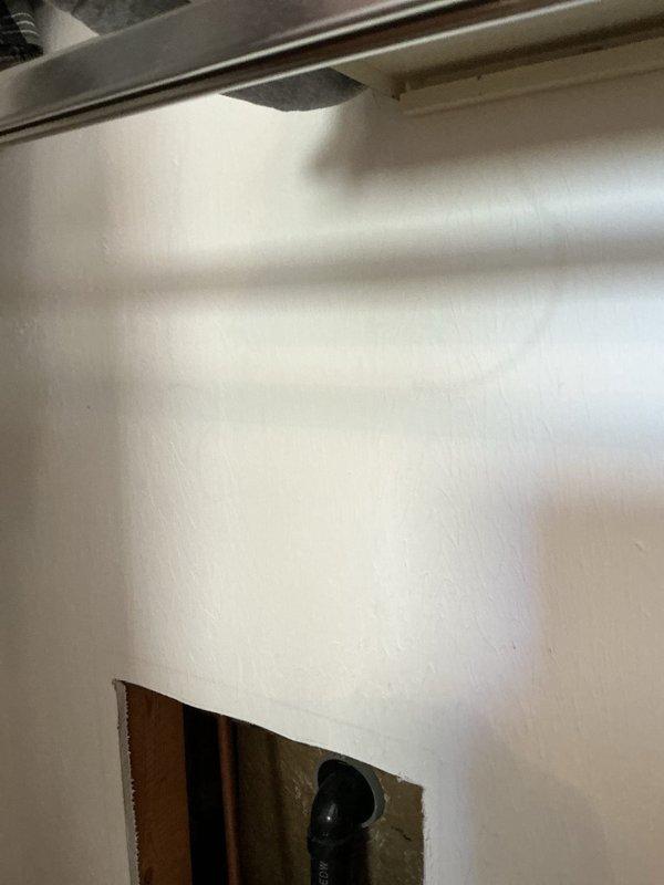 Responded to service call for non-functioning shower in bathtub/shower combination unit. Performed diagnostic inspection of chrome shower valve control, tub spout, and associated plumbing fixtures. Created wall access opening to expose concealed plumbing lines and drainage system behind fiberglass surround for proper assessment and repair of shower malfunction.
