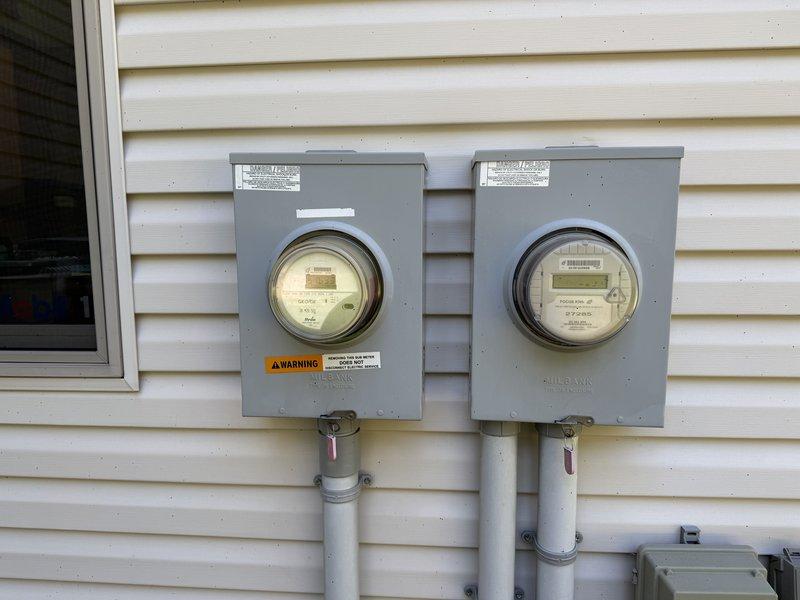 Completed electrical estimate for Kohler generator installation requiring propane fuel source. Assessed existing dual-meter residential electrical service with Landis+Gyr and Milbank meters, documented current panel configuration including main distribution panel with multiple circuit breakers and two additional sub-panels mounted on OSB backing board in basement utility area. Evaluated electrical infrastructure, conduit routing, and available space to determine generator integration requirements and transfer switch placement for seamless backup power system installation.