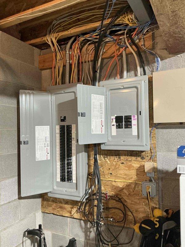 Completed electrical estimate for Kohler generator installation requiring propane fuel source. Assessed existing dual-meter residential electrical service with Landis+Gyr and Milbank meters, documented current panel configuration including main distribution panel with multiple circuit breakers and two additional sub-panels mounted on OSB backing board in basement utility area. Evaluated electrical infrastructure, conduit routing, and available space to determine generator integration requirements and transfer switch placement for seamless backup power system installation.