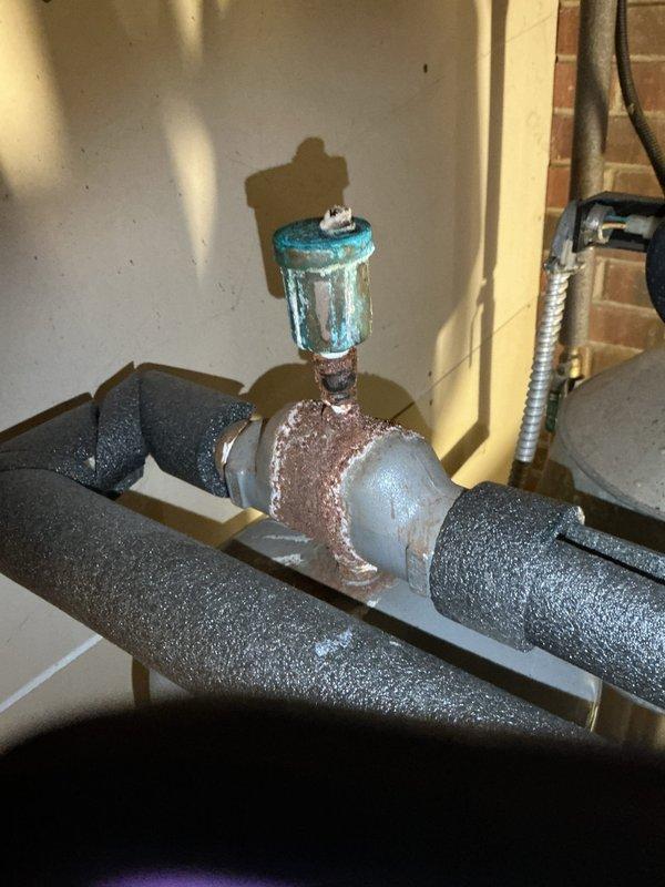 Responded to no-heat call for boiler system that would not fire. Upon arrival, performed diagnostic inspection of heating system including circulator pump assembly, piping connections, and associated components. Identified heavily corroded tee-joint fitting with rust deterioration that was compromising system integrity and potentially affecting proper boiler operation. Documented existing conditions of blue circulator pump unit showing age-related wear, multiple zone valves, copper and black iron piping connections, and expansion tank. System evaluation revealed maintenance concerns requiring attention to restore reliable heating operation.