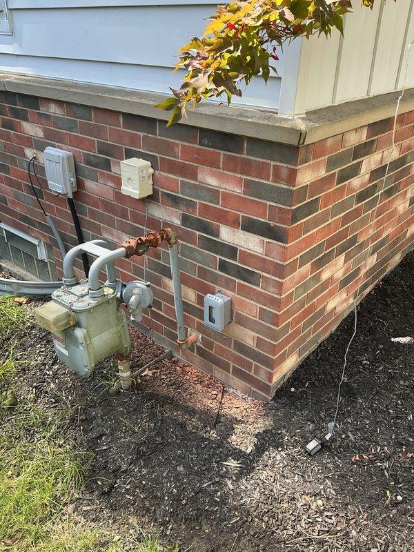 Installed two new dedicated 120V circuits for exterior holiday decoration outlets. First circuit was run from the basement subpanel to a new weatherproof receptacle mounted near the front of the home at foundation level. Second circuit was installed from the main electrical panel to a new exterior outlet positioned just inside the fence line near the garage area. Both circuits were wired with appropriate gauge copper conductors, protected with GFCI breakers, and terminated in weather-resistant outlet boxes with in-use covers mounted on the exterior brick foundation. All work completed to current NEC standards for outdoor receptacle installations.