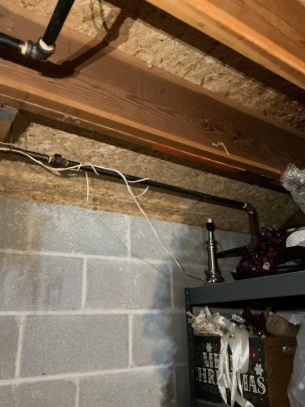Installed new electrical outlet in fireplace area and ran wiring through basement ceiling joists for overhead light fixture in front room. Routed cables along existing joist structure, securing with appropriate fasteners, and verified all connections met code requirements for safe operation.