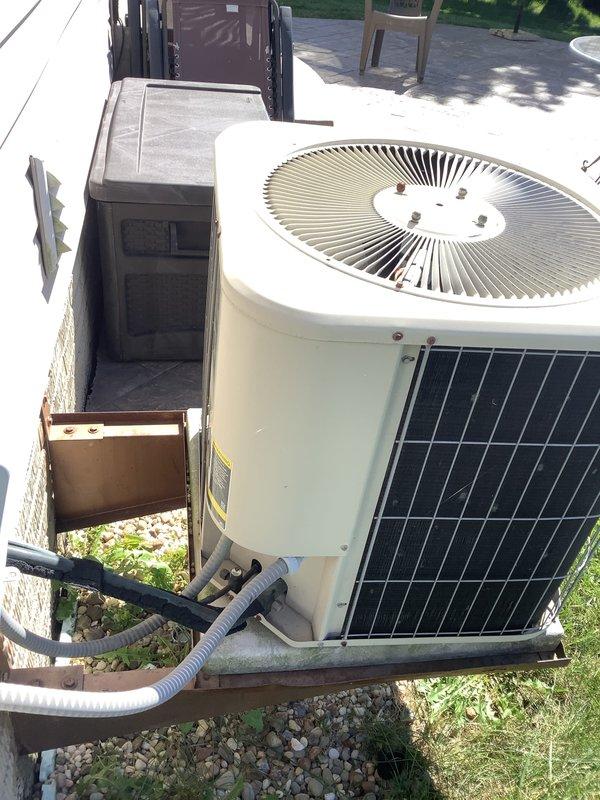 Conducted on-site evaluation of existing HVAC system for replacement estimate at a two-story, 1800 square foot residential property with basement installation. Assessed 23-year-old furnace unit located in basement and 23-year-old air conditioning condenser positioned on exterior concrete pad. Documented current equipment configuration including PVC venting arrangement on furnace and refrigerant line routing on outdoor unit. Photographed both components to support replacement recommendations for aging system that has reached end of typical service life expectancy.
