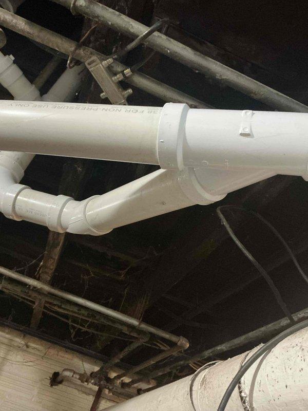 Replaced defective waste and overflow assembly and removed a section of severely deteriorated drain piping in the basement that was actively leaking. Installed new white PVC drainage piping with proper fittings and connections to restore functionality and eliminate water damage. All new plumbing components were secured to existing structural supports and tested for proper drainage flow.