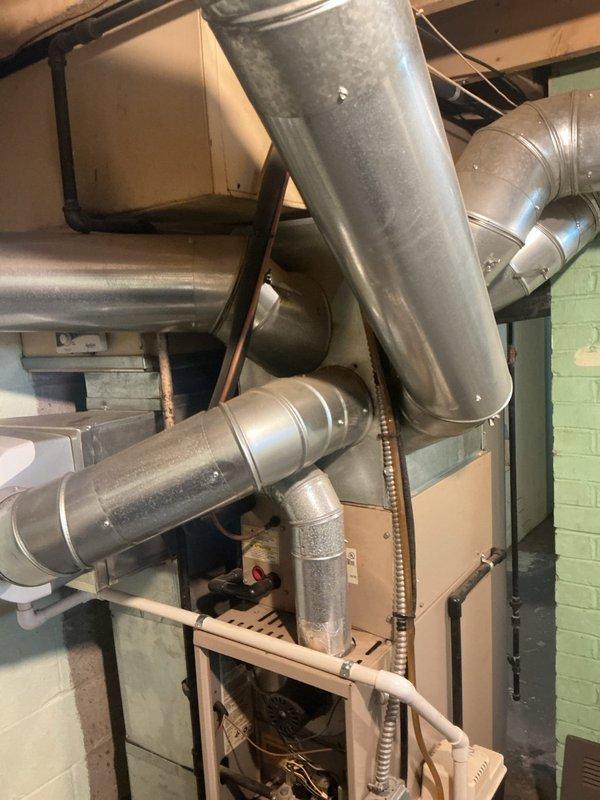 Responded to service call for 20+ year old gas furnace with non-operational blower motor. Upon inspection, accessed furnace system in confined basement mechanical space and assessed ductwork configuration and HVAC equipment installation. Documented existing conditions of furnace unit, ductwork connections, and overall system layout to determine cause of blower failure and restore heating operation.