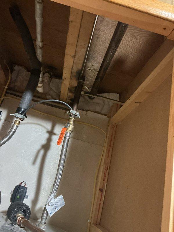 Responded to basement water leak complaint and conducted thorough inspection of plumbing systems. Located and repaired leaking water heater connections, including tightening brass fittings on flexible braided supply lines and addressing compromised connections at the water heater inlet. Inspected exposed plumbing infrastructure in ceiling joists and confirmed no additional active leaks in visible piping systems. Tested all repaired connections under full water pressure to verify leak elimination and proper system operation.