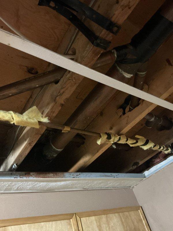 Responded to basement water leak complaint and conducted thorough inspection of plumbing systems. Located and repaired leaking water heater connections, including tightening brass fittings on flexible braided supply lines and addressing compromised connections at the water heater inlet. Inspected exposed plumbing infrastructure in ceiling joists and confirmed no additional active leaks in visible piping systems. Tested all repaired connections under full water pressure to verify leak elimination and proper system operation.