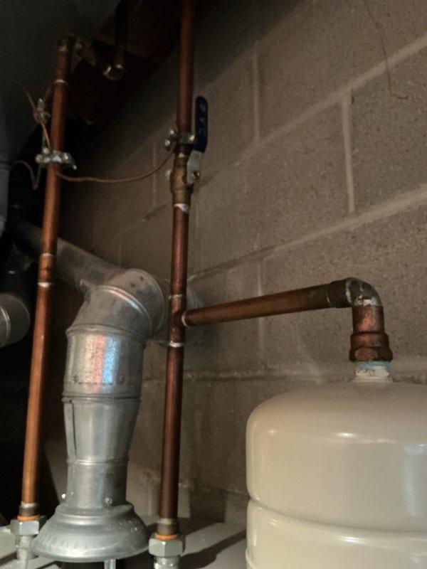 Provided quote for replacement of 50-gallon gas water heater with regular vent configuration in tall form factor. Upon inspection, found severe corrosion on top of existing unit, particularly at the copper pipe connections and tank outlet fittings, with visible green copper oxidation and brown rust deposits indicating advanced deterioration. The existing HANDYMAN-branded water heater showed significant age-related wear with corroded brass fittings and compromised piping connections at the tank top. Documented existing installation including galvanized vent piping, copper supply lines, pressure relief valve assembly, and expansion tank configuration for accurate replacement specifications.