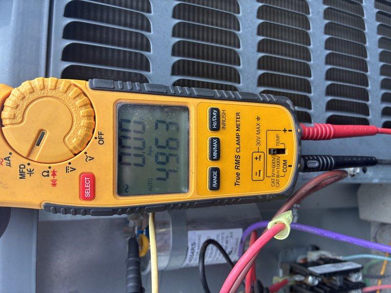 Completed preventive maintenance inspection on residential air conditioning system for MVP customer. Performed electrical diagnostics using digital multimeter, recording voltage readings of 33.52V and 46.4V at the outdoor condensing unit. Inspected condenser coils, which were found to be clean and in good condition. Examined outdoor disconnect box and contactor assembly, noting operational components with minor age-related weathering present in enclosure. System operating within normal parameters; documented findings with photos for customer records.