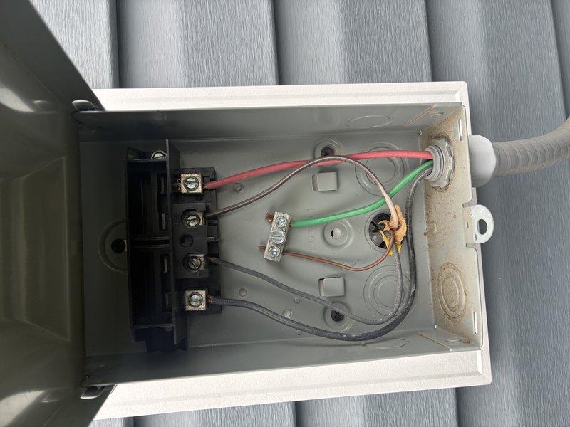 Completed preventive maintenance inspection on residential air conditioning system for MVP customer. Performed electrical diagnostics using digital multimeter, recording voltage readings of 33.52V and 46.4V at the outdoor condensing unit. Inspected condenser coils, which were found to be clean and in good condition. Examined outdoor disconnect box and contactor assembly, noting operational components with minor age-related weathering present in enclosure. System operating within normal parameters; documented findings with photos for customer records.