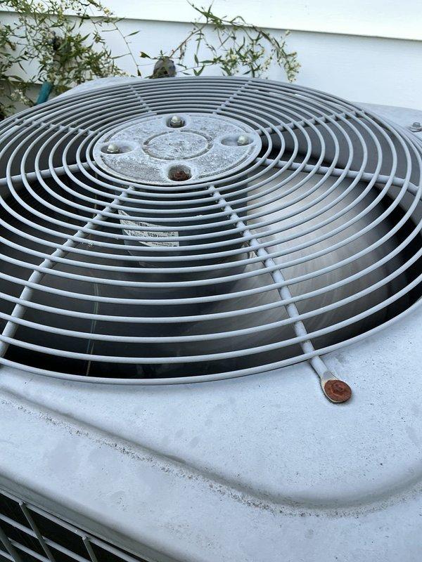 Completed comprehensive MVP Cool maintenance on an 18-year-old outdoor condensing unit. Performed standard preventive maintenance procedures including inspection of fan motor operation, electrical connections, and refrigerant lines. Unit showing age-appropriate wear with weathering on exterior housing and surrounding vegetation requiring clearance for proper airflow and accessibility during future service visits.