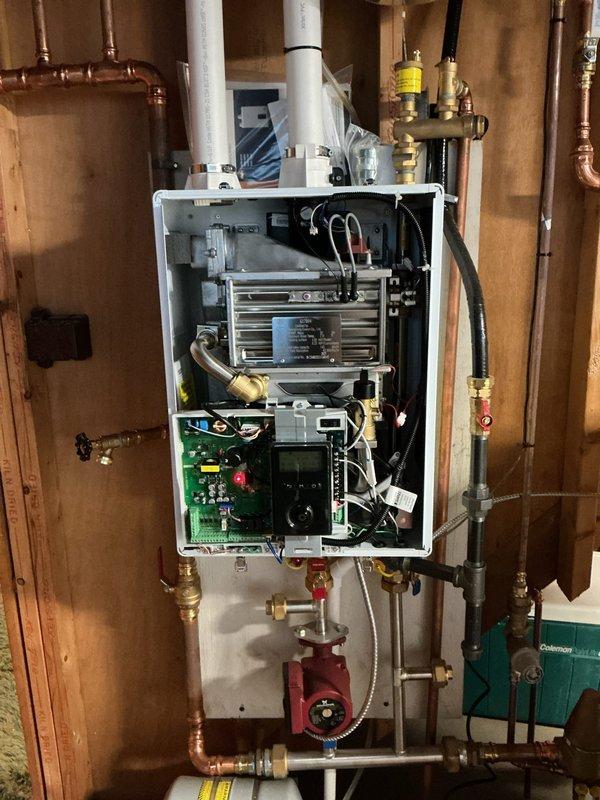 Responded to service call for 9-year-old boiler system experiencing recurring low water pressure error codes causing unit shutdowns despite pressure gauge readings appearing within normal range. Performed diagnostic inspection of wall-mounted boiler unit, examined internal components including circuit board, heat exchanger, and associated piping connections. Inspected pressure relief valve, expansion tank, fill valve assembly, and circulation pump for proper operation. Verified system pressure readings on both mechanical gauge and digital control display showing 185°F supply temperature and DHW off status. Checked all copper piping connections, shut-off valves, and system controls for leaks or irregularities that could trigger false low-pressure alarms. System restored to normal operation with error code resolved.