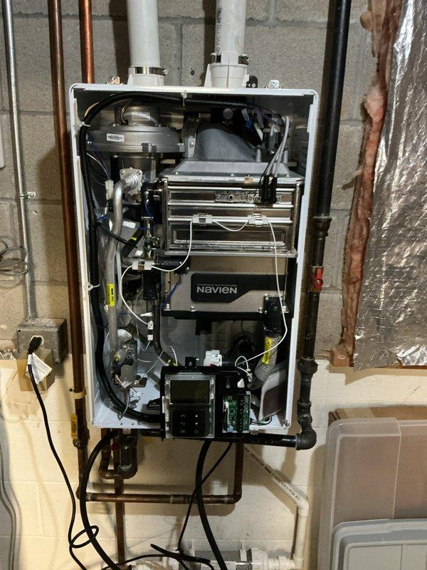 Performed routine maintenance flush on Navien tankless water heater unit. Removed front access panel to expose internal components and completed thorough descaling flush of the heat exchanger system. Inspected and cleaned inlet filter screen, which showed minor sediment accumulation consistent with normal operation. All internal components, including heat exchanger, circulation pump, and electrical connections, were inspected and found to be in good working condition. Reinstalled filter screen and secured front panel. Unit tested and operating within normal parameters upon completion.