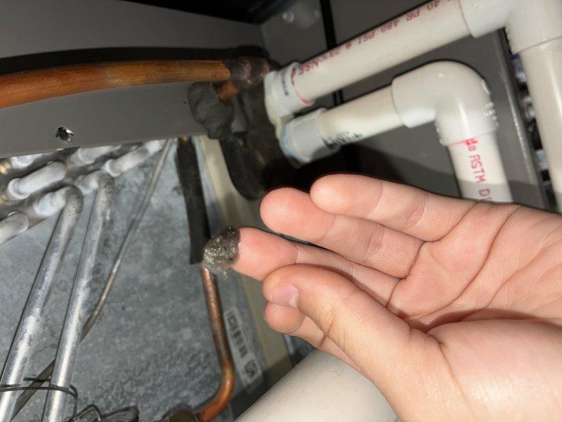 Responded to water leak complaint on 2-year-old Lennox AC unit (EL18XCV-036-230A03). Found condensate catch basin malfunctioning, causing water to discharge from overflow pipe onto floor. Inspected condensate drain system including PVC drainage lines and internal catch pan. Cleared blockage in primary drain line, verified proper pitch and flow through condensate piping, and tested safety float switch operation. Confirmed unit cycling properly with condensate draining correctly through primary line without overflow. System returned to normal operation with no further water leakage observed.