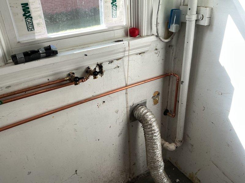 Removed old gate valves with missing handles in the laundry room and rebuilt the tees for the laundry hookup using new copper piping and fittings. Installed new hose bibs to replace the deteriorated fixtures. On the exterior side of the house, cut out the existing gate valve and installed a new frost-free sillcock with ball valve. Located and cut the abandoned 1/2" water line and properly capped it off to prevent future issues.