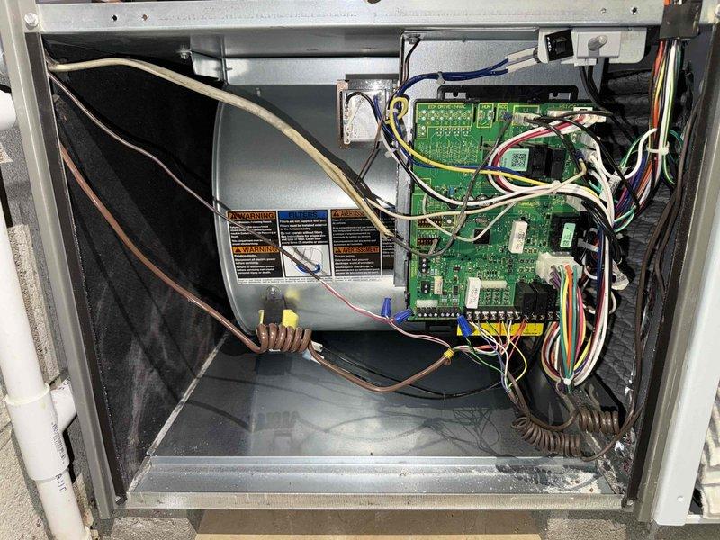 Completed comprehensive furnace maintenance inspection and system evaluation. Removed access panel to examine internal components, including blower assembly, control board, and electrical connections. Inspected green circuit board PCB with all electronic components, DIP switches, and LED display module showing proper configuration and functionality. Verified wire harnesses, connections, and routing throughout unit were secure with appropriate wire management. Noted accumulated dust and debris on blower compartment filter area. Examined drain pan, interior cabinet condition, and all manufacturer safety labels. All electrical components, including integrated circuits, resistors, and control system connections, found to be in proper working order with no signs of damage or wear.