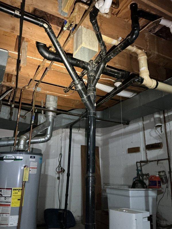 Responded to service call for tanked water heater with pilot light failure. Upon arrival, inspected water heater unit located in basement utility area and assessed the condition of the appliance and surrounding plumbing infrastructure. The water heater exhibited symptoms consistent with thermocouple malfunction or gas valve issues preventing the pilot light from remaining lit. Documented existing conditions including overhead drainage system with black PVC piping, water supply lines, and mechanical room configuration. Evaluated the water heater's operational components, connections, and safety systems to determine the cause of pilot light failure and provided assessment for necessary repairs or replacement considerations.