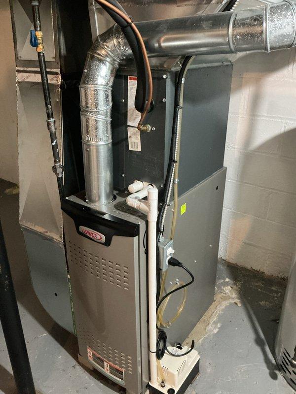 Completed comprehensive MVP AC maintenance on residential cooling system. Serviced Lennox furnace unit and associated indoor components in basement mechanical room, including inspection of ductwork, refrigerant lines, and connected humidifier system. Addressed outdoor condenser unit which was significantly overgrown with vegetation and ground cover that had encroached on equipment, restricting airflow to coils and fan assembly. Cleared all plant growth, vines, and debris from around and on top of condenser unit to restore proper ventilation and prevent potential damage to fins and coils. Verified system operation and airflow efficiency following vegetation removal and standard maintenance procedures.