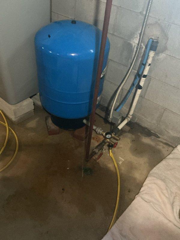 Responded to service call for leaking well pressure tank in basement. Upon arrival, coordinated timing with customer to provide required advance notice. Inspected blue pressure tank system and identified active leak at tank connection points. Assessed complete well water system including pressure tank, pump assembly, brass manifold fittings, shut-off valves, pressure gauge, and associated copper and PVC piping. 

Diagnosed leak source and performed necessary repairs to pressure tank connections and plumbing assembly. Verified all brass fittings, valve connections, and pipe joints for proper seal integrity. Tested system pressure and monitored for any additional leaks. Confirmed pump operation and pressure tank functionality after repairs were completed. Left work area clean and system fully operational.