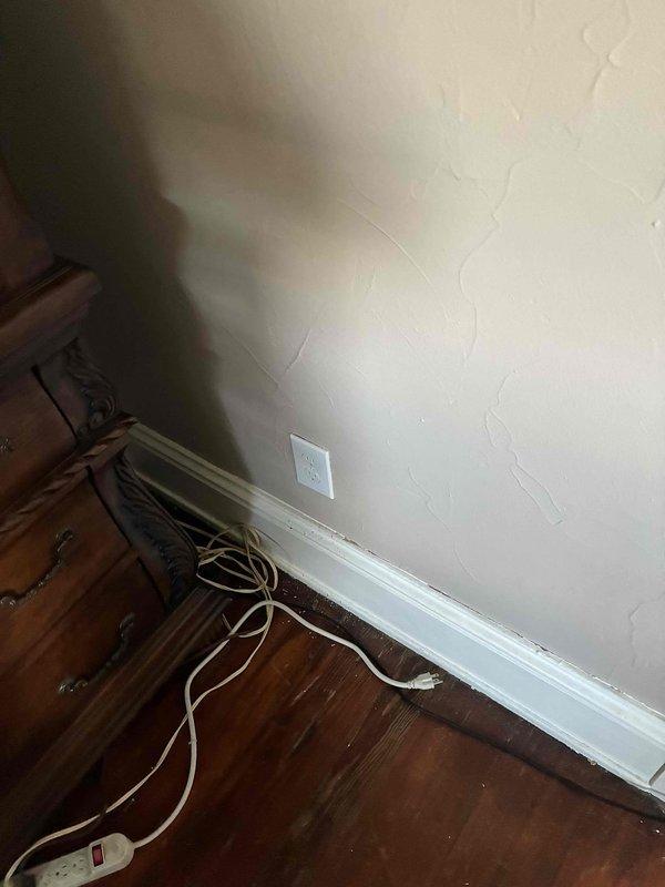 Responded to callback for damage assessment and repair related to previous installation work. Upon arrival, inspected electrical service equipment at exterior meter location and documented existing installation condition. Investigated reported issue with refrigerator circuit and structural joist that was inadvertently damaged during prior electrical installation. Assessed interior wall outlet location and surrounding area where damage occurred. Documented both exterior service panel configuration and interior affected area with photographs for records and potential repair coordination.