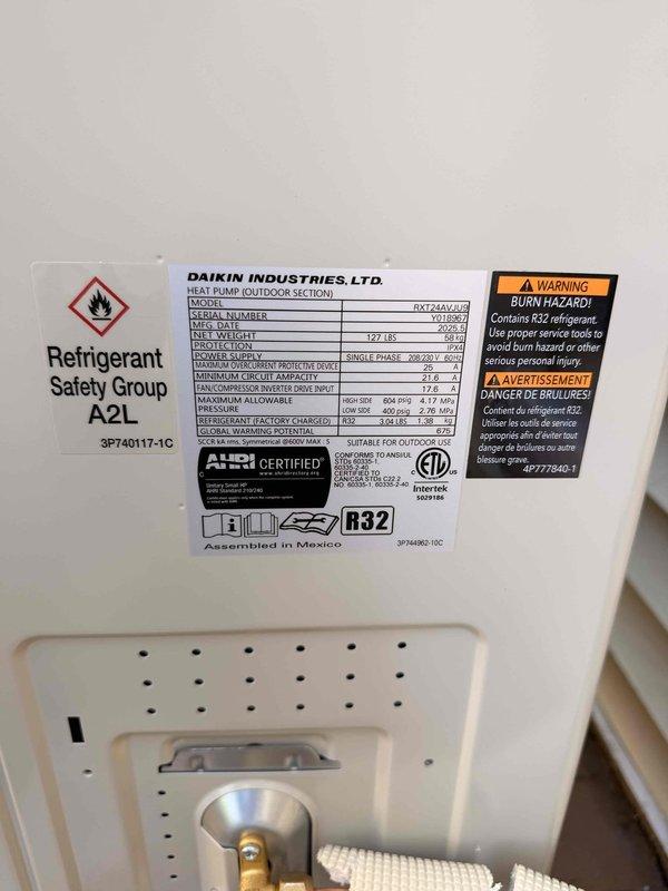 Completed changeout of existing mini split system to new 2-ton Daikin hyper heat unit, model DXT24AAVU2, utilizing R32 refrigerant. Installed outdoor condenser section with proper electrical disconnect and wiring connections, verified all safety labels and manufacturer specifications are visible and compliant, and removed old unit from premises for return to shop.