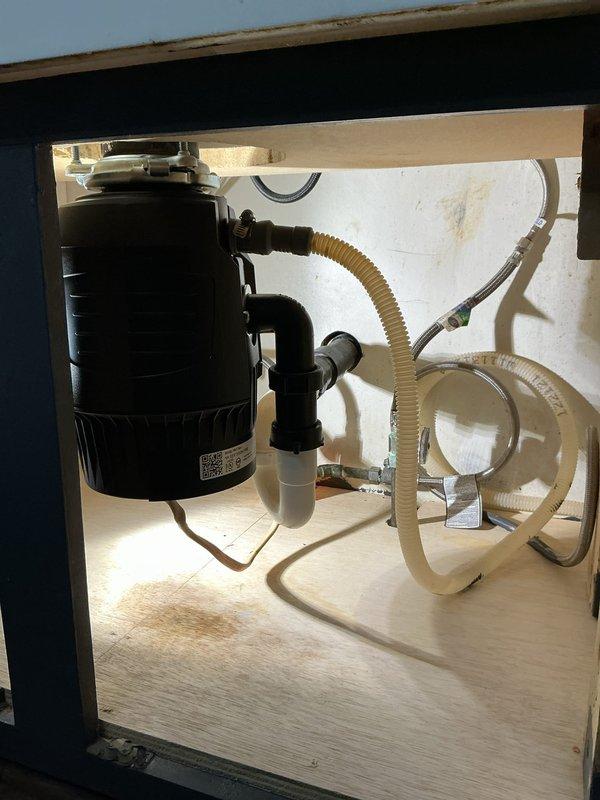 Replaced failed InSinkErator Badger 5 garbage disposal that was leaking from the bottom seal. Removed existing unit from sink mounting assembly and disconnected hardwired electrical connection. Installed new 3/4 horsepower disposal unit with quiet technology, reconnected to existing sink drain flange, and rewired electrical using hardwired configuration. Verified proper P-trap alignment, tested unit operation and drainage, and confirmed no leaks at mounting points or drain connections.