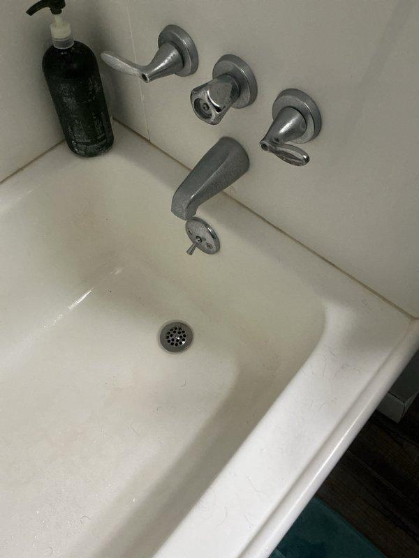 Responded to service call for bathtub not holding water when plugged. Inspected tub drain assembly from access point below fixture and identified faulty drain stopper mechanism preventing proper seal. Accessed underfloor plumbing through crawlspace, verified P-trap and drainage lines were clear and functioning properly. Documented existing three-handle tub valve configuration and drain assembly condition with photos for customer review and approval of recommended repairs.