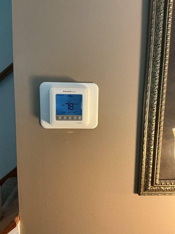 Completed warranty installation of Honeywell Home digital thermostat at residential location. Replacement unit was previously ordered and received at shop prior to service call. Removed defective thermostat, installed new unit on existing wall plate, verified proper wiring connections, and confirmed system operation with accurate temperature display and control functionality.