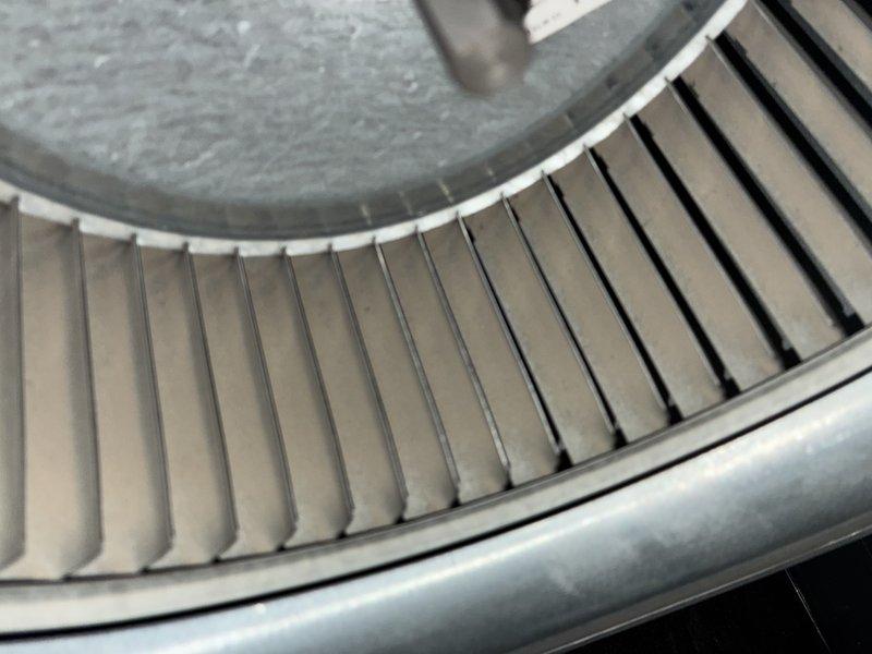 Completed scheduled MVP heating maintenance visit. Inspected blower assembly and documented condition of squirrel cage fan, noting dust accumulation on fan blades and housing. Photographed small white plastic component, likely a mounting bracket or sensor holder, for maintenance records.