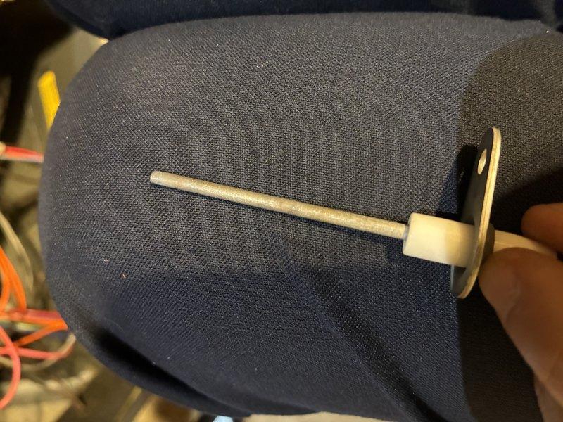 Completed scheduled MVP heating maintenance visit. Inspected blower assembly and documented condition of squirrel cage fan, noting dust accumulation on fan blades and housing. Photographed small white plastic component, likely a mounting bracket or sensor holder, for maintenance records.