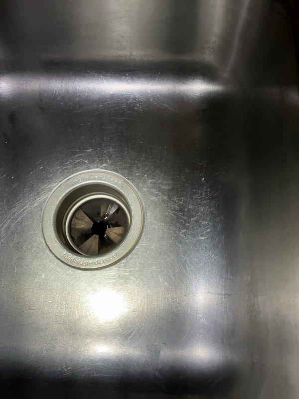 Removed and replaced failed garbage disposal unit with customer-supplied unit. Disconnected existing disposal from sink mounting assembly, electrical connection, and drain lines. Installed new disposal unit, securing mounting flange to sink drain opening, connecting dishwasher drain line with hose clamp, and attaching discharge pipe to existing drain system. Restored electrical power and tested unit for proper operation and verified no leaks at connections.