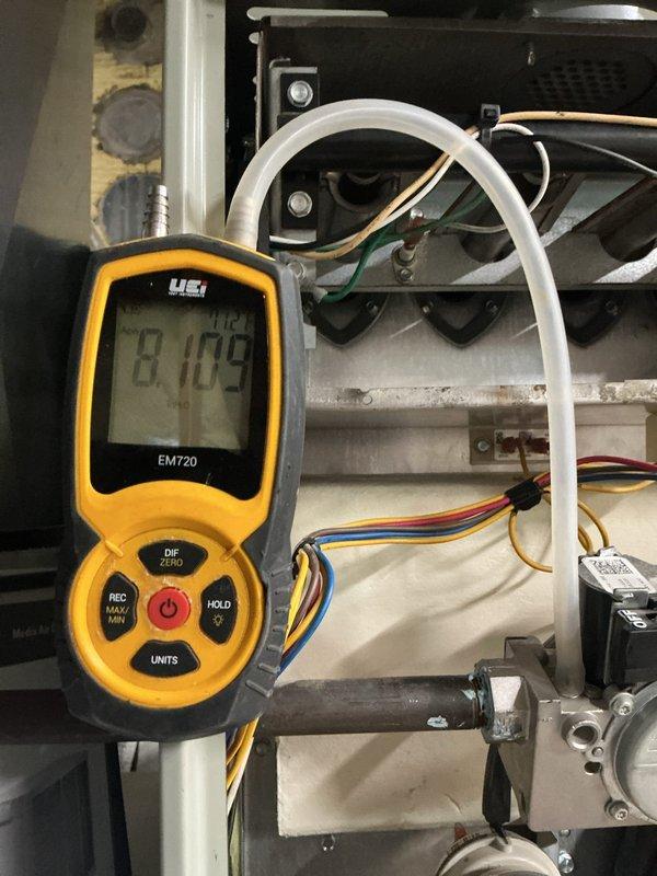 Completed MVP furnace maintenance on residential heating system. Performed comprehensive system inspection and diagnostics using digital multimeter to verify proper electrical readings and system performance. Measured and documented amperage draw at 8.109 amps, confirming unit is operating within manufacturer specifications. Inspected pressure switch assembly, including tubing connections and diaphragm components, ensuring proper operation for safe furnace cycling. Examined gas valve, burner assembly, and ignition components for proper function. Verified all wiring connections, including control board circuits and safety switches. Checked condensate drainage system including PVC piping and trap assembly. All components found to be functioning correctly with no immediate repairs required. System tested and left in proper working order.