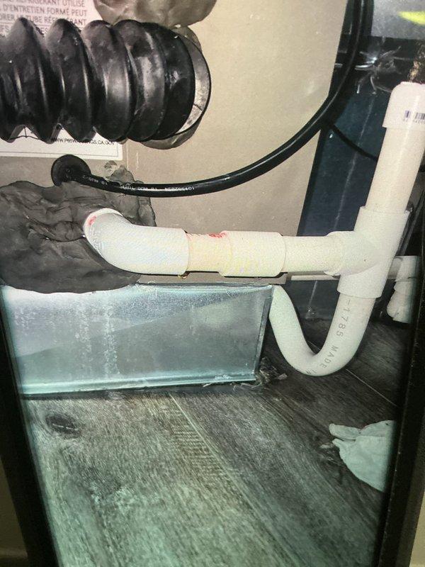 Responded to service call back for ongoing furnace leak issue. Upon arrival, inspected Lennox furnace unit and traced moisture source to condensate drainage system. Found active leaking at PVC condensate trap assembly with water accumulating in drip pan beneath unit. Observed water staining and damage on floor surface indicating prolonged moisture exposure. Condensate drain line connections showed improper pitch causing backup and overflow. Cleared condensate trap of debris, re-configured PVC piping for proper drainage slope, and tested system operation under full load. Verified condensate flow through drain line without backup or leakage. Monitored unit through complete heating cycle to confirm issue resolved.