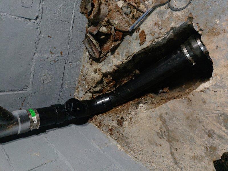 Responded to basement flooding caused by failed sewer stack fitting beneath concrete floor. Jackhammered basement floor around the sewer stack to access the compromised fitting at the concrete penetration point. Removed damaged fitting and installed new connection, tying back into the existing ABS drain line above the concrete. Completed concrete excavation, pipe replacement, and reconnection to restore proper drainage and prevent further water intrusion.