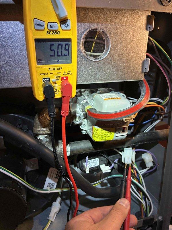 Completed MVP heating maintenance visit on residential HVAC system. Performed comprehensive system inspection of outdoor condenser unit and internal electrical components. Utilized digital multimeter to verify proper electrical readings, measuring 50.9 volts at capacitor terminals to ensure system operating within manufacturer specifications. Inspected all electrical connections, wiring harnesses, and control board components for signs of wear or damage. All components functioning properly with no issues identified during diagnostic testing.