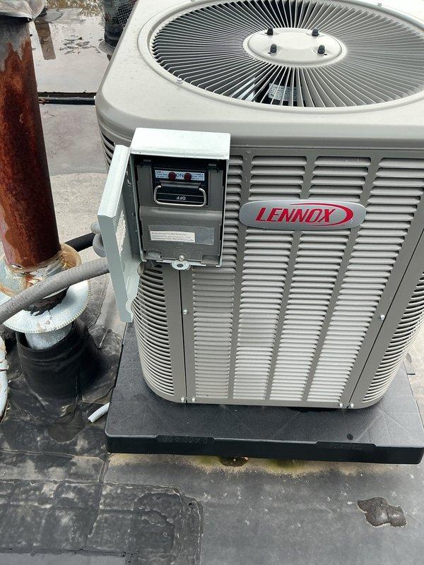 Responded to no cooling complaint with water leaking through ceiling from recently installed Lennox rooftop unit. Upon inspection, found extensive standing water pooling on flat commercial roof surface due to inadequate drainage, with debris accumulation around multiple roof penetrations and HVAC equipment. Documented significant roofing membrane deterioration, compromised drainage system, and water intrusion points near unit installation. Identified warranty-covered equipment as potential source of condensate leak contributing to ceiling water damage. Photographed roof conditions, standing water patterns, unit installation, refrigerant line connections showing weathering, and drainage deficiencies for warranty claim documentation and recommended immediate roof drainage remediation to prevent further water intrusion and equipment damage.