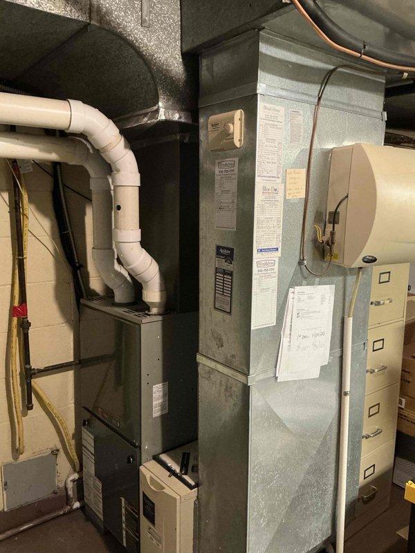 Conducted comprehensive furnace replacement estimate at residential property. Evaluated existing gray metal furnace unit in basement mechanical room, documenting current system configuration including white PVC venting, copper gas line routing, and auxiliary humidifier component. Assessed equipment age, condition, and compatibility requirements for replacement system recommendations, capturing detailed photos of existing installation for proposal development.