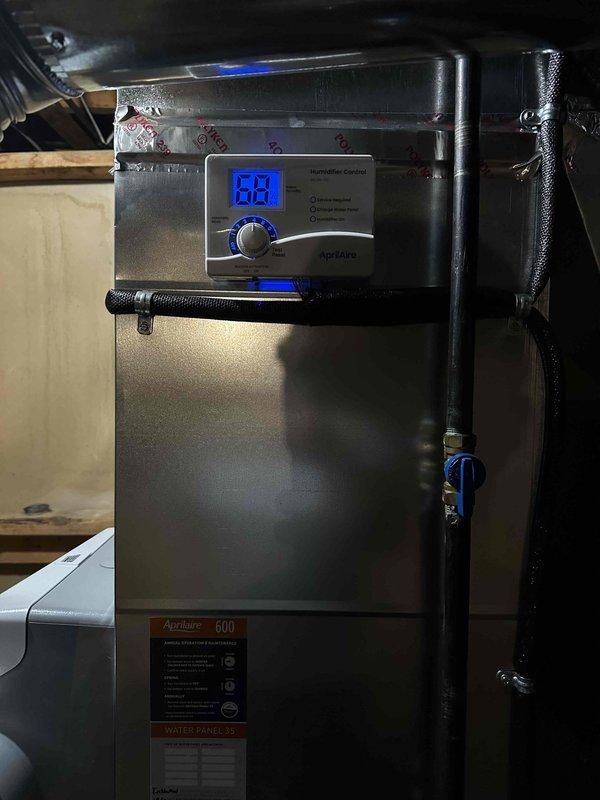 Installed AprilAire 600 whole-home humidifier system on existing HVAC furnace unit. Mounted humidifier control panel on furnace cabinet with digital display and manual dial control, connected water supply line via copper piping with shutoff valve in ceiling space, and installed water panel evaporator assembly. System tested and operational, with control set to maintain desired humidity levels throughout the home.