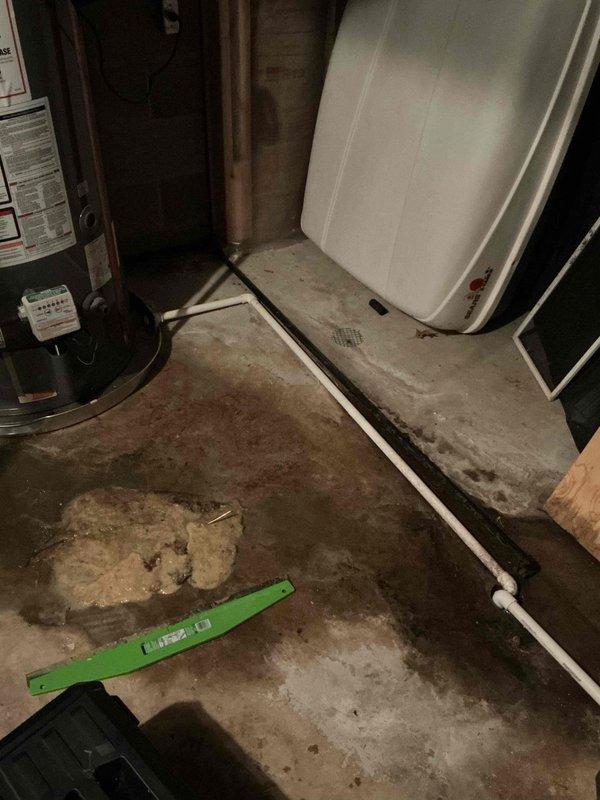 # HVAC Service - Water Leak

Responded to service call for water leaking from bottom of one of two Lennox furnaces in basement. Upon arrival, inspected both units and surrounding area. Observed water accumulation on concrete floor near affected furnace and evidence of moisture-related staining. 

Used level to check furnace installation and confirmed unit positioning. Identified condensate drainage issue as source of leak. Inspected condensate drain line, trap, and associated plumbing connections. Found blockage preventing proper drainage, causing water to overflow from condensate collection system.

Cleared obstruction from condensate drain line and verified proper flow. Tested condensate pump operation and confirmed functionality. Cleaned debris from drain pan and surrounding area. Checked secondary drain safety switch for proper operation. Verified all drainage components functioning correctly with no further leakage observed.

Documented conditions with photographs showing equipmen