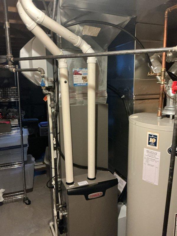 # HVAC Heating Maintenance Completed

Performed comprehensive MVP heating maintenance on residential forced air furnace system. Conducted thorough inspection of furnace unit, verified proper operation of all mechanical components, and checked refrigerant lines and ductwork connections for integrity. Examined condensate drainage system with white PVC piping to ensure proper flow and prevent backup issues. Inspected thermostat control functionality and verified accurate temperature regulation. Assessed all visible ductwork including flexible black ducts and metallic supply runs for secure connections and proper airflow. Confirmed water heater and associated plumbing systems in mechanical room were operating safely alongside HVAC equipment. System operating within normal parameters with no immediate concerns identified.