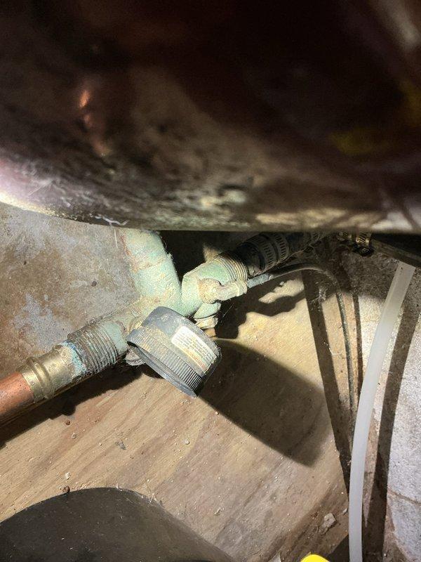 Responded to emergency water leak in basement originating from failed pressure tank near water softener system. Upon arrival, confirmed homeowner had shut off well pump breaker to stop active high-pressure spray, leaving property without running water. Performed diagnostic inspection and identified compromised pressure tank requiring replacement. Documented existing plumbing configuration including copper supply lines, ball valve assembly, and connections to water heater system. Assessed installation requirements and confirmed proper replacement supplies needed for pressure tank swap-out to restore water service before guests' arrival.