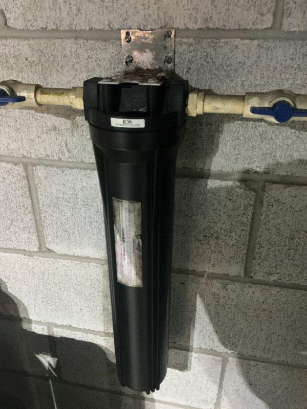 Responded to service call regarding possible rust discoloration in water supply. Performed visual inspection of tanked water heater and associated plumbing system, including PEX supply lines and whole-house water filtration unit mounted on basement wall. Examined water heater condition, checking for signs of internal tank corrosion, sediment buildup, and proper operation of anode rod. Inspected filter housing and cartridge for rust particles or sediment accumulation that could indicate source of discoloration. Evaluated condition of copper and PEX piping connections for any signs of galvanic corrosion or deterioration. Documented equipment configuration with photographs showing water heater installation with color-coded PEX supply lines and inline filtration system. No active leaks, unusual noises, or immediate safety concerns observed during inspection.