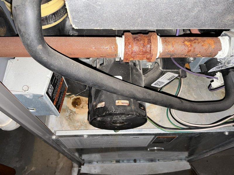 Performed estimate on 13-year-old furnace system presenting with leaking and noisy inducer motor. Upon inspection, identified significant corrosion on copper piping and deteriorating inducer motor assembly requiring replacement. Documented equipment condition with photographs showing advanced rust on horizontal piping, corroded connections, and overall system wear consistent with age. Provided quote for complete furnace replacement due to extent of deterioration and cost-effectiveness compared to component repair on aging equipment.